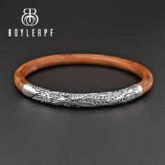 Beautiful and super collectible, this vintage bracelet features an elaborate sterling silver phoenix bird design front and a rattan bamboo band. Detailed with the phoenix bird in flight, the silver band is hallmarked 925 for content. 