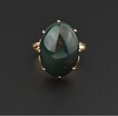 This stunning vintage ring, handcrafted in 14K yellow gold, showcases a gorgeous oval 10.5 carat cabochon bloodstone. The heliotrope cabochon has rich colors of dark green chalcedony with splashes of red jasper which is the reason it is called a bloodstone. Bloodstone was treasured not only as a talisman of good health and long life but was reputed to bring its owner respect, good fortune, riches, and fame. Fantastic vintage ring with a rich meaning!