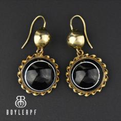 Elegant antique solid yellow gold bullseye banded agate earrings. Each bullseye cabochon agate is solid black with a thin band of white and wrapped in and 18K gold twist. Suspended from round button tops with a hook wires, the pierced antique earrings, circa 1800s, are perfect for a special anniversary or birthday gift.